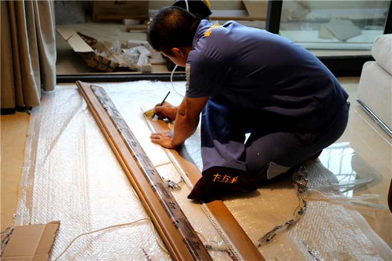 左右手家具安裝師傅專(zhuān)心的按照?qǐng)D紙下料